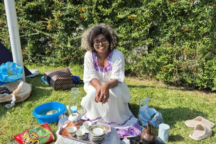 Jonge vrouw van gemixte komaf is aan het picknicken tijdens een Buurt camping