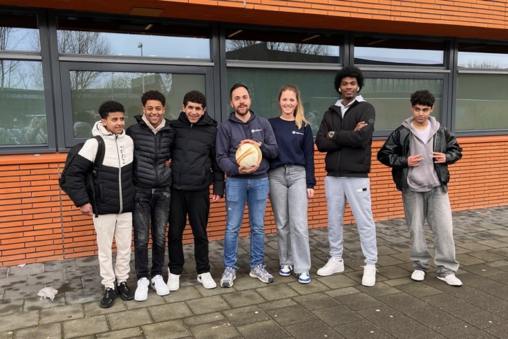 Jongeren en leerkracht voor hun school